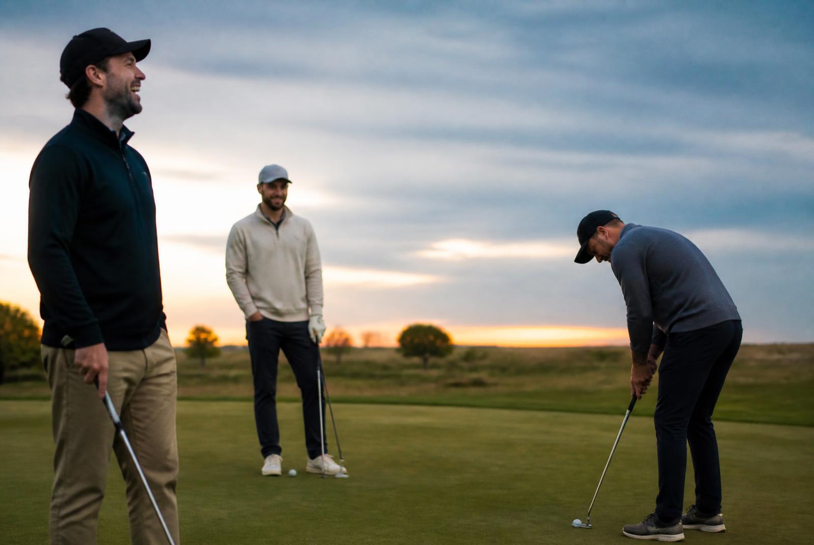 Friends playing an evening round of golf on the prairie