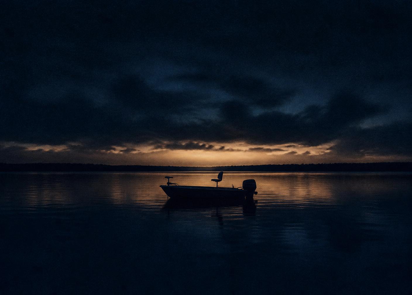 A boat on a calm prairie lake at dusk